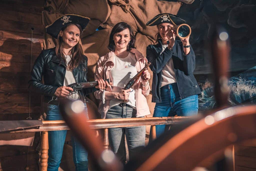 Trzy młode kobiety przebrane za piratów podczas tematycznej imprezy firmowej