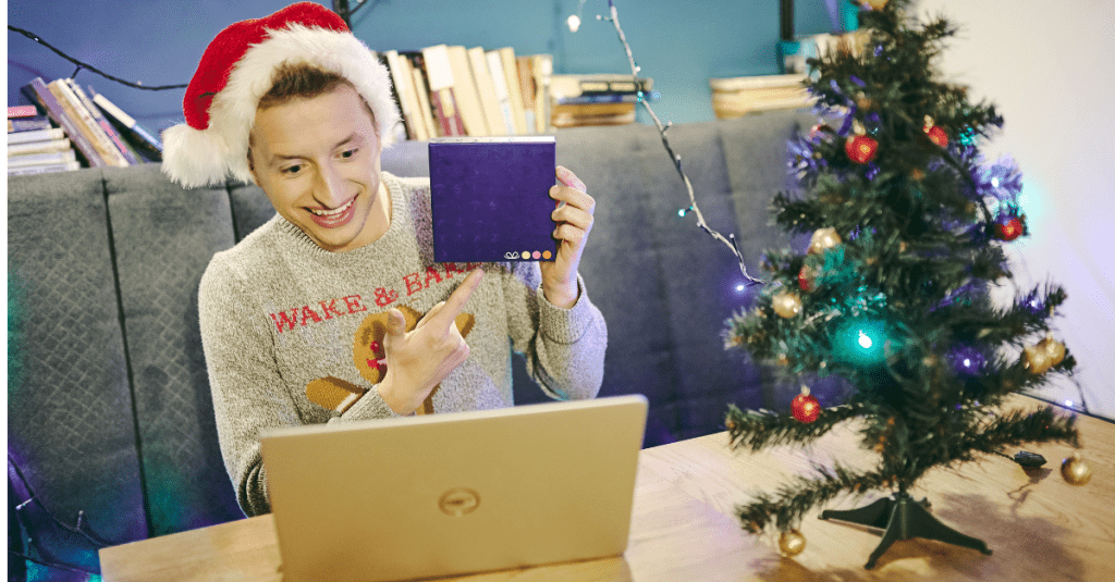 Pracownik pokazuje prezent podczas spotkania świątecznego online