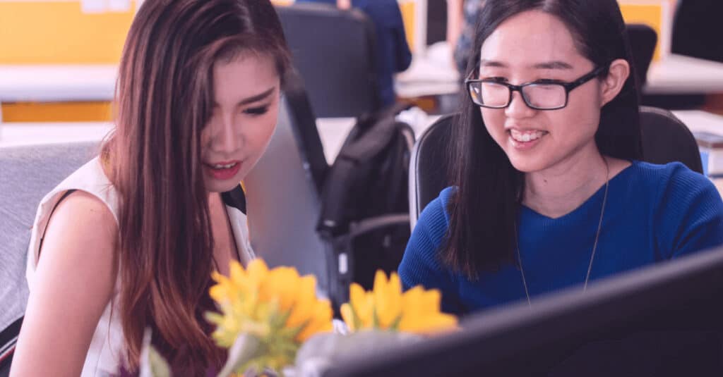 Uśmiechnięte pracownice przy komputerze - Dzień Kobiet w pracy