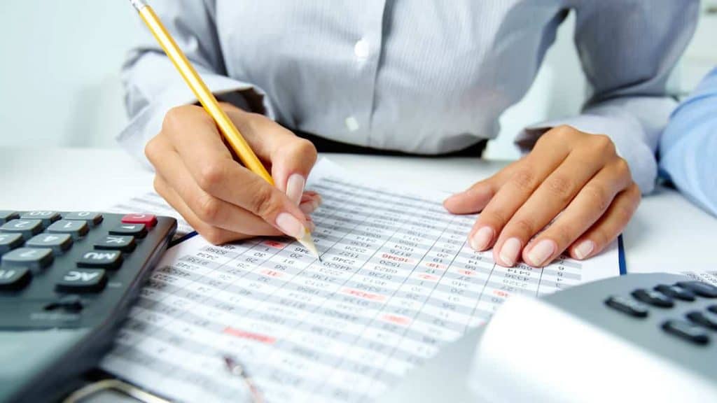 Kobieta wypełnia tabelę podatkową i rozlicza prezenty dla pracowników